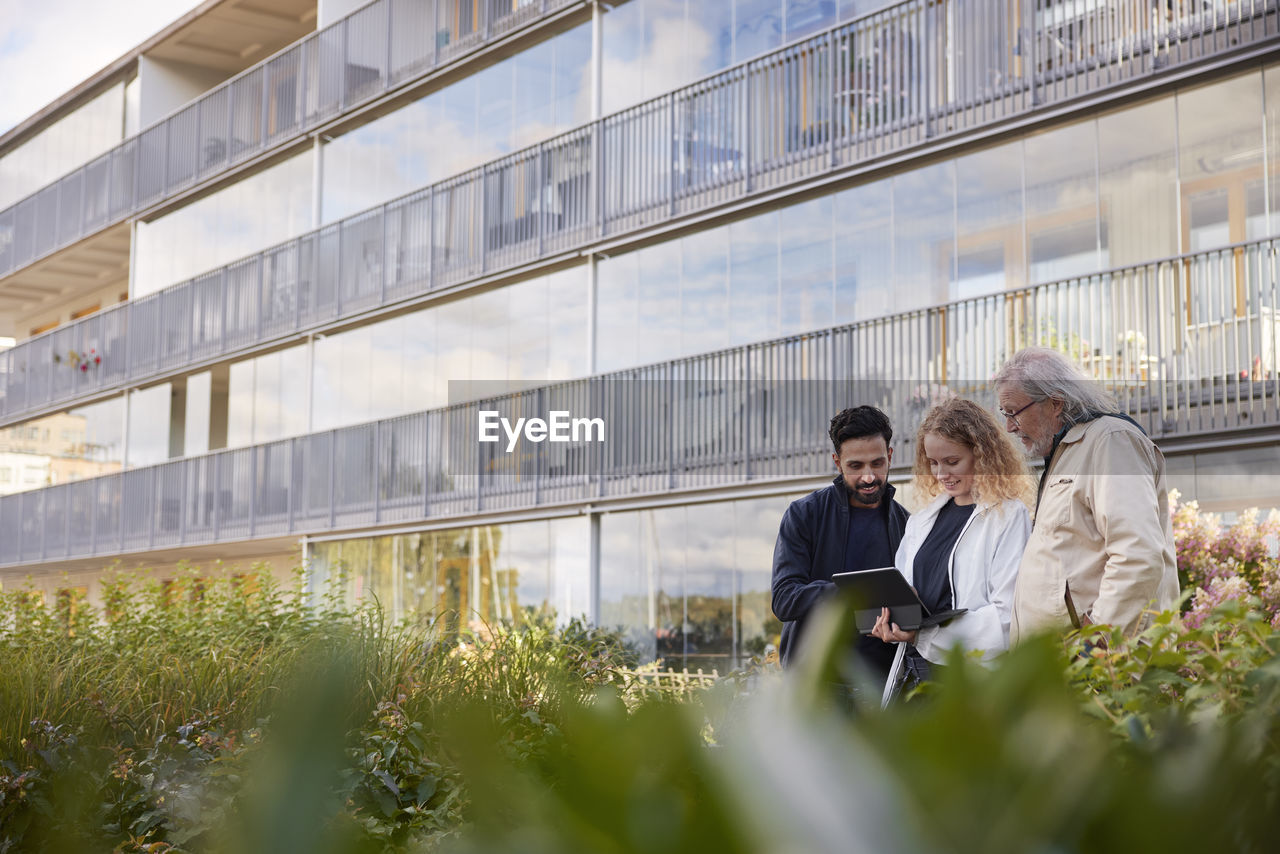 Men and woman with laptop in courtyard