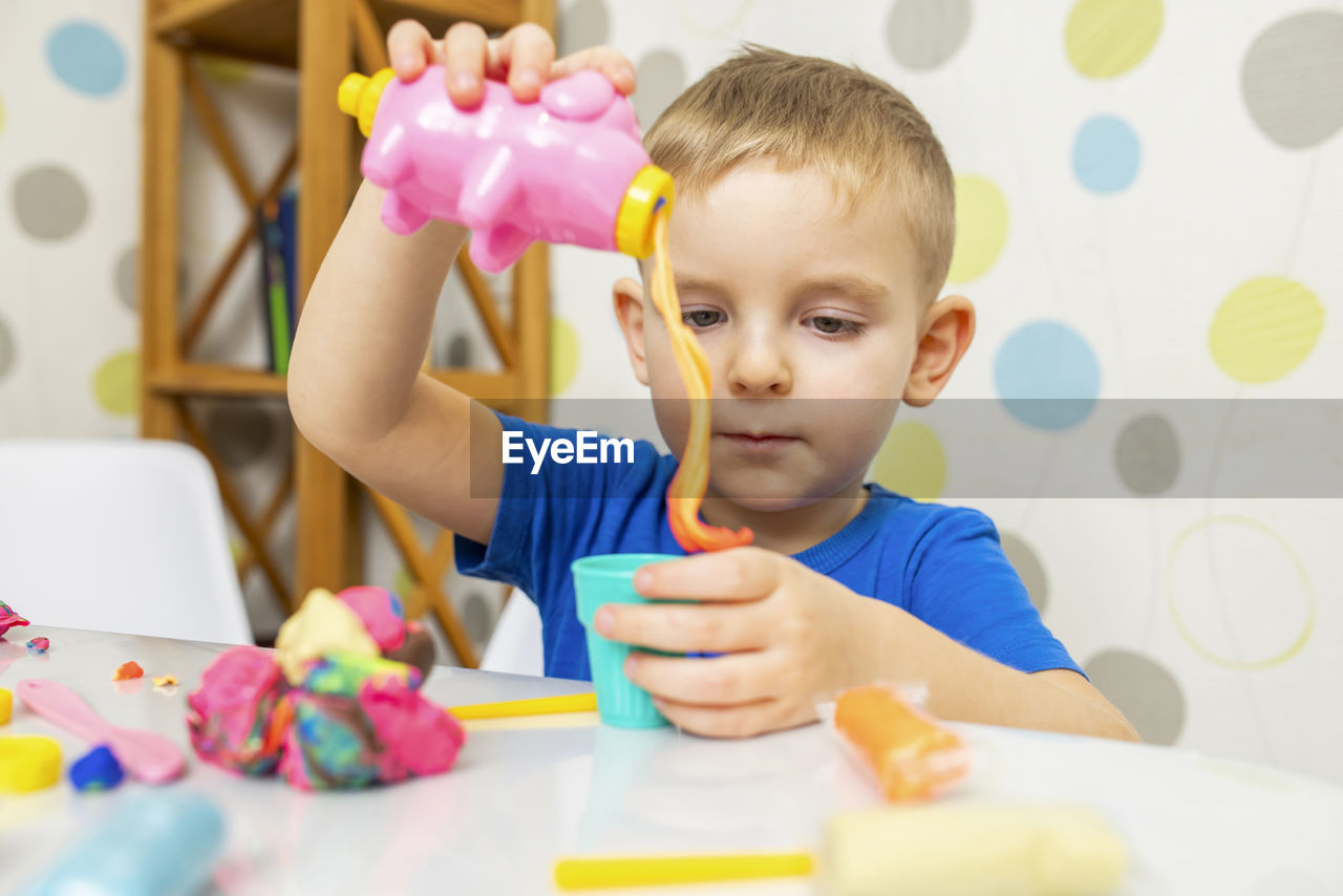 portrait of boy playing with toys on table