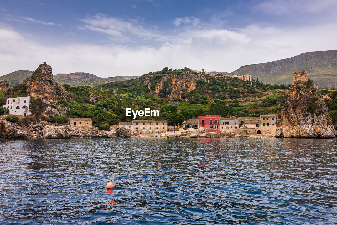 Scenic view of sea and buildings against sky