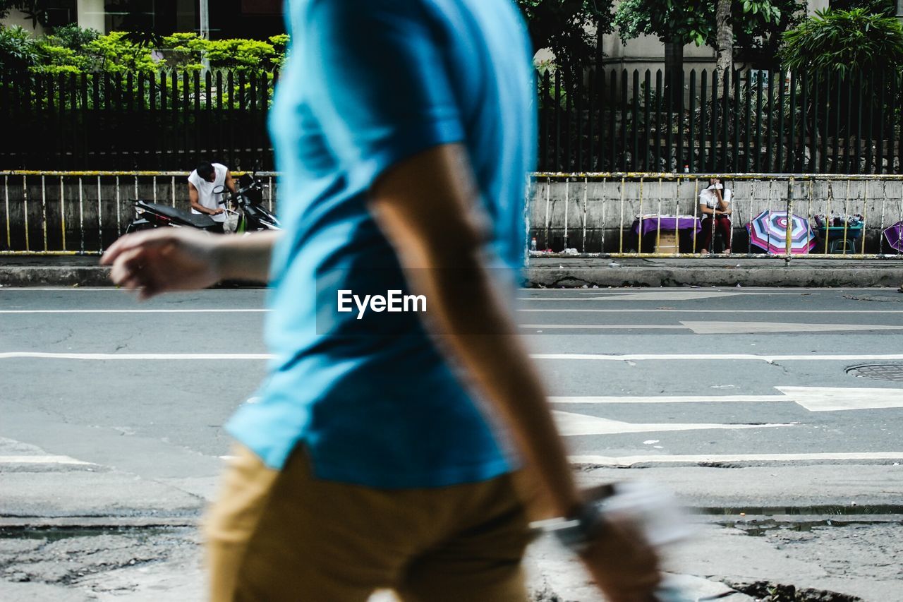 Blurred motion of man walking by street