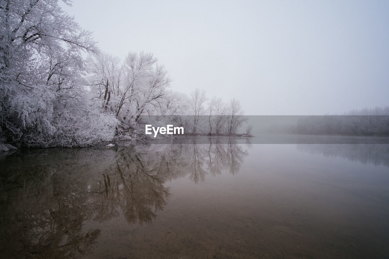 Scenic view of lake against clear sky during winter