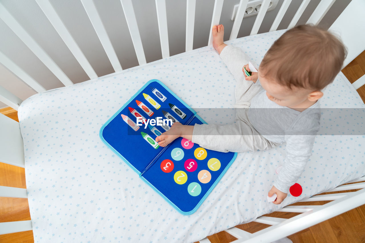 high angle view of cute baby girl playing with toy on table