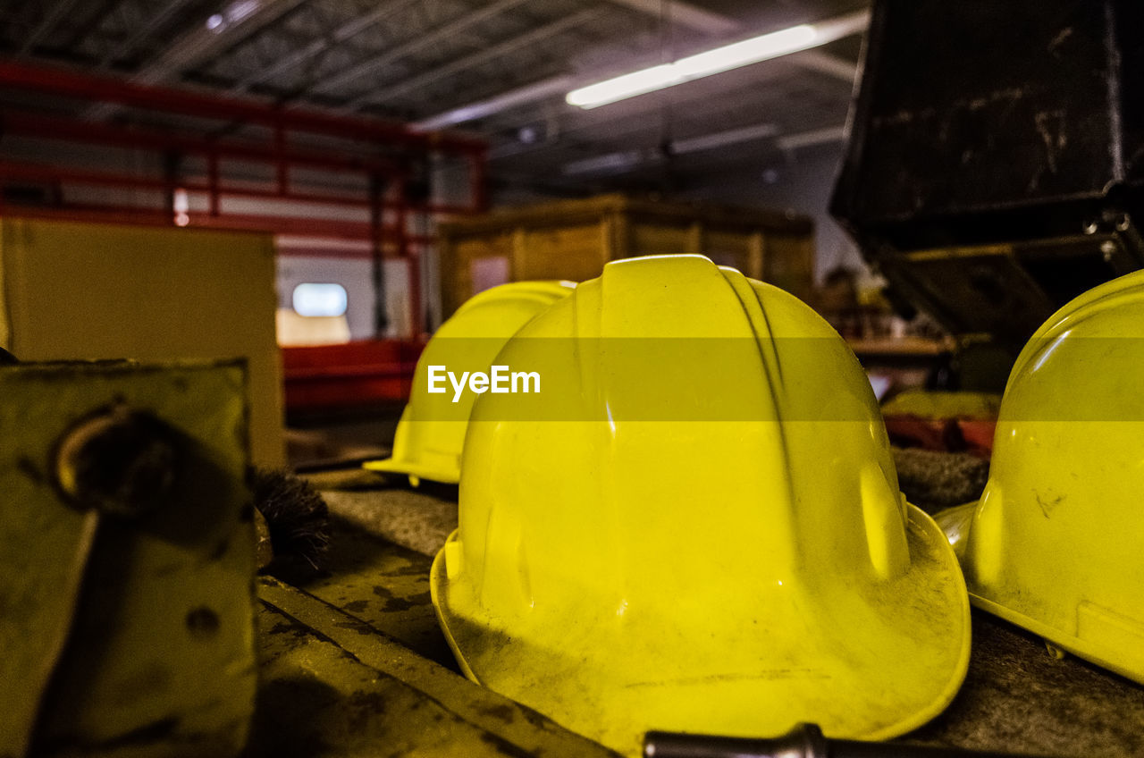 Close-up of yellow helmets in workshop