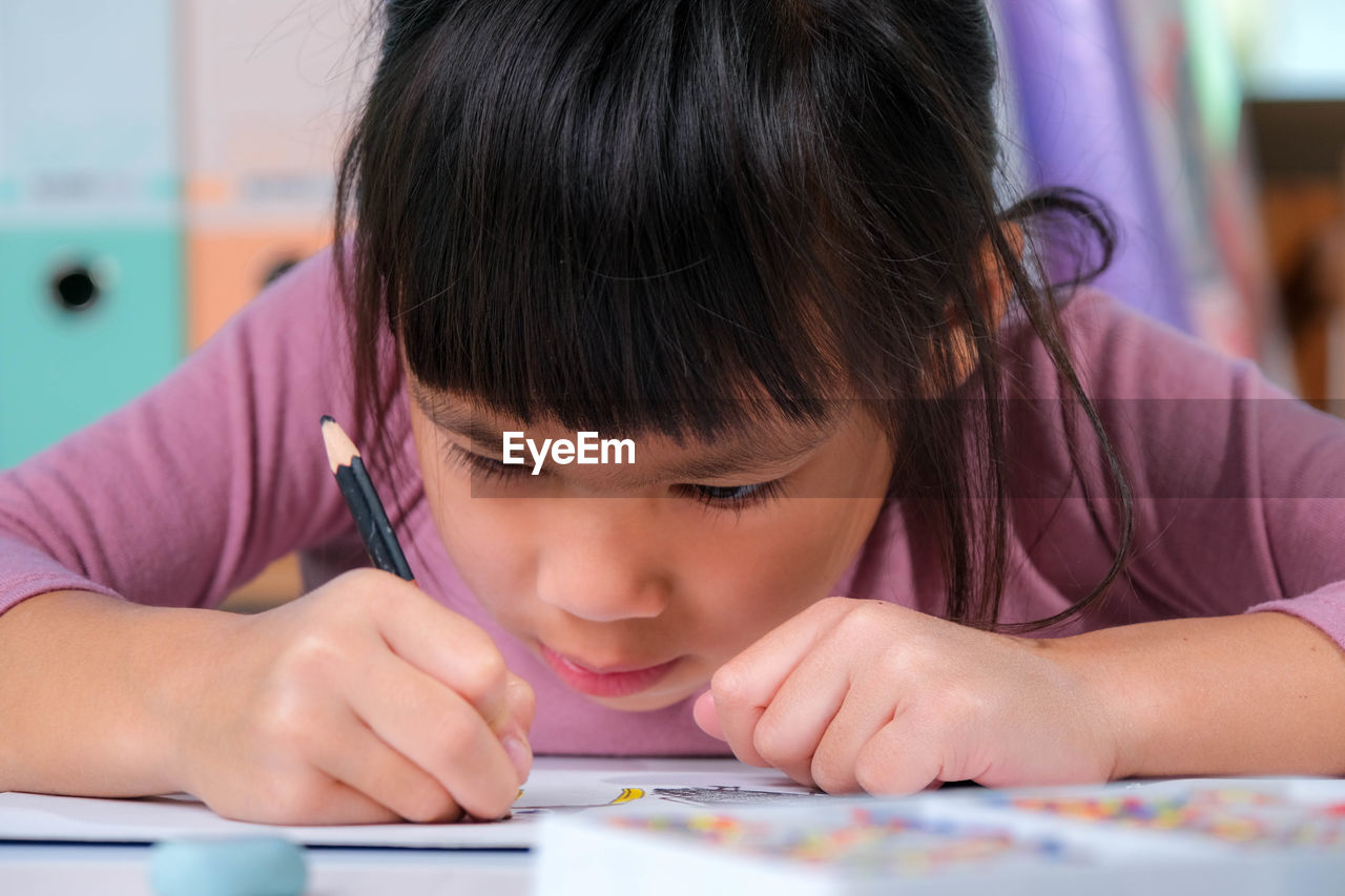 close-up of girl drawing on book