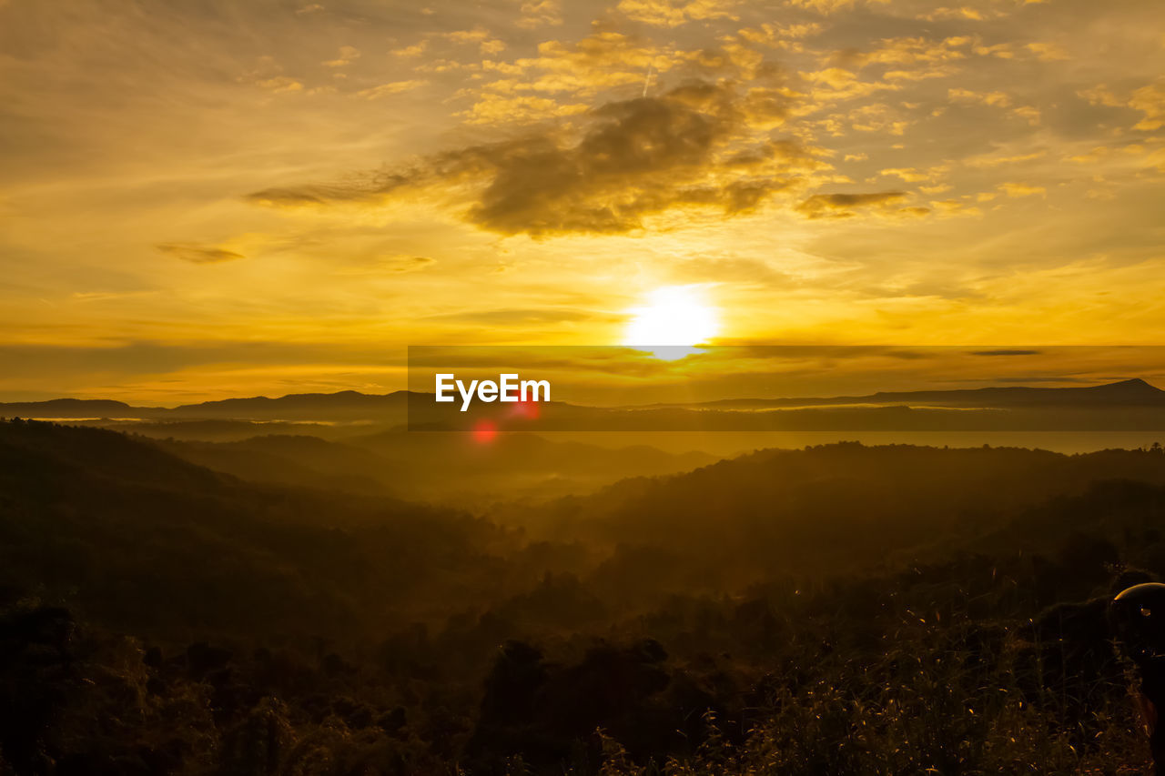 SCENIC VIEW OF MOUNTAINS AGAINST ORANGE SKY
