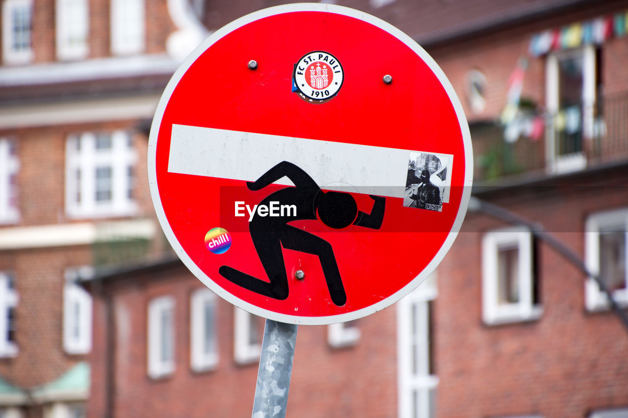 CLOSE-UP OF ROAD SIGN AGAINST BUILDINGS