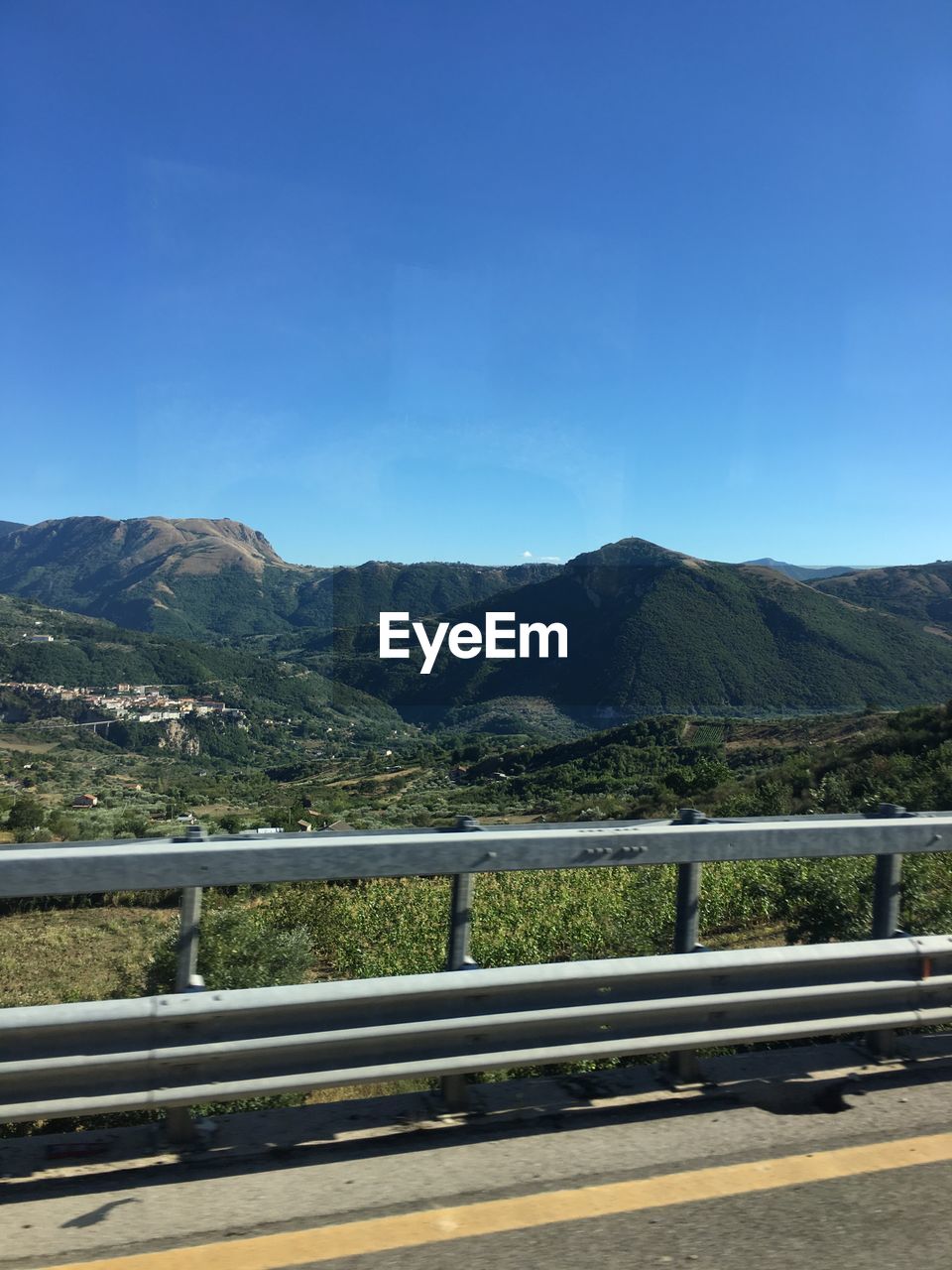 RAILING AND MOUNTAINS AGAINST SKY