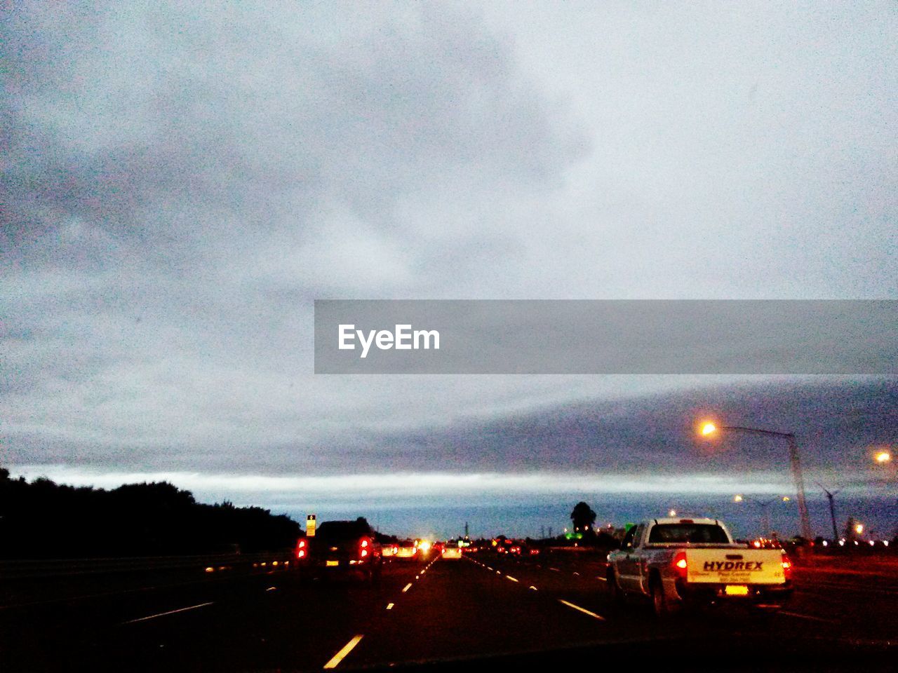 VIEW OF ROAD AGAINST CLOUDY SKY