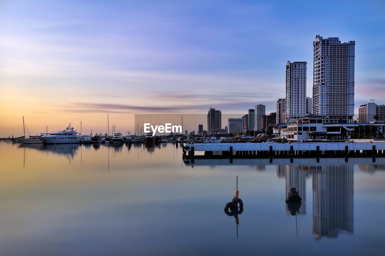 SAILBOATS IN CITY DURING SUNSET