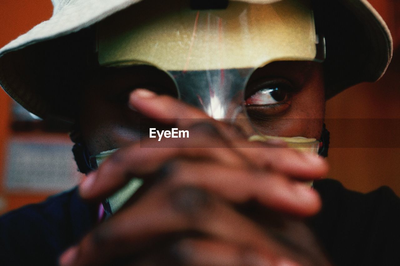 Close-up of man wearing mask with hands clasped