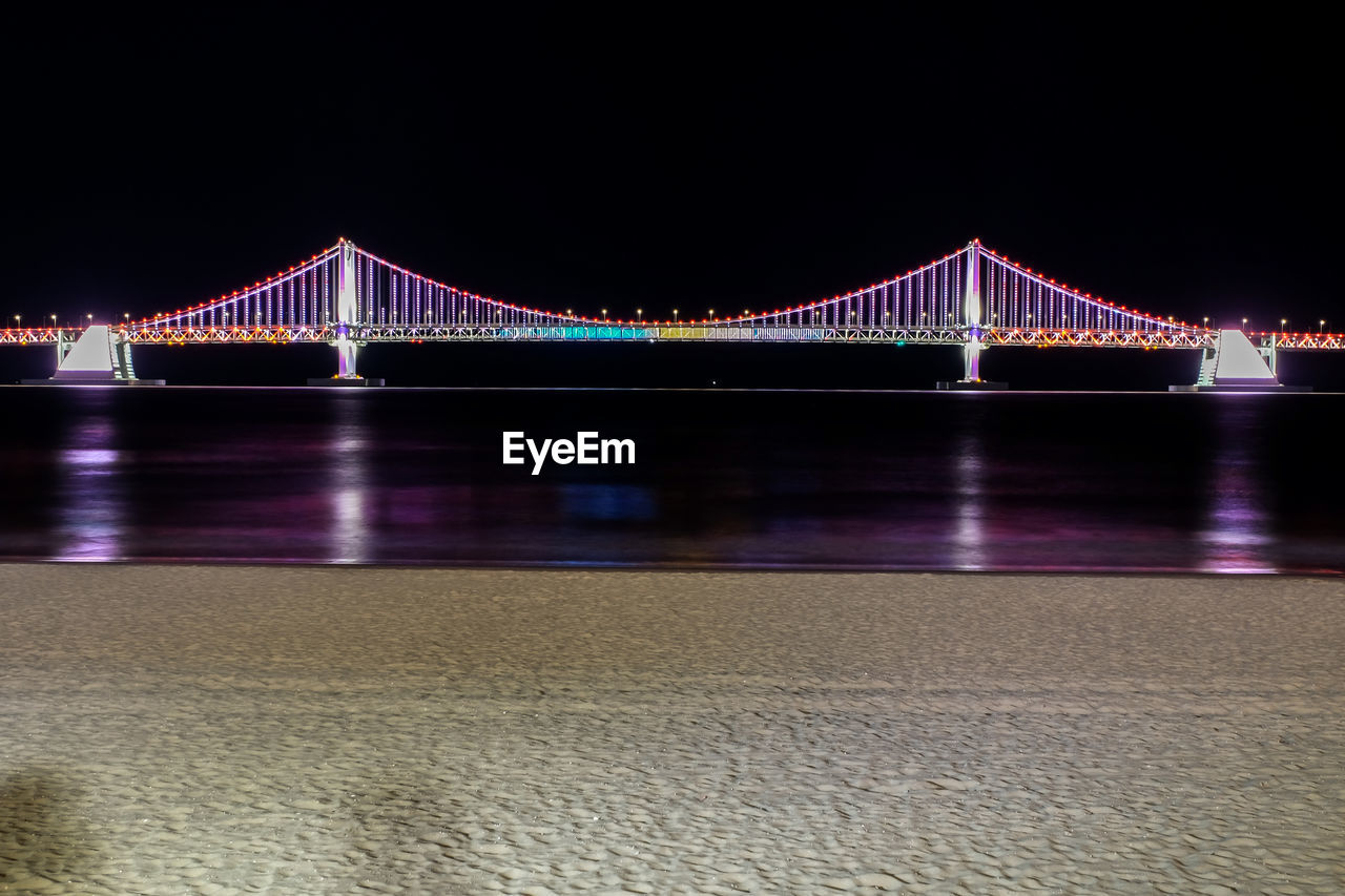 ILLUMINATED BRIDGE OVER RIVER