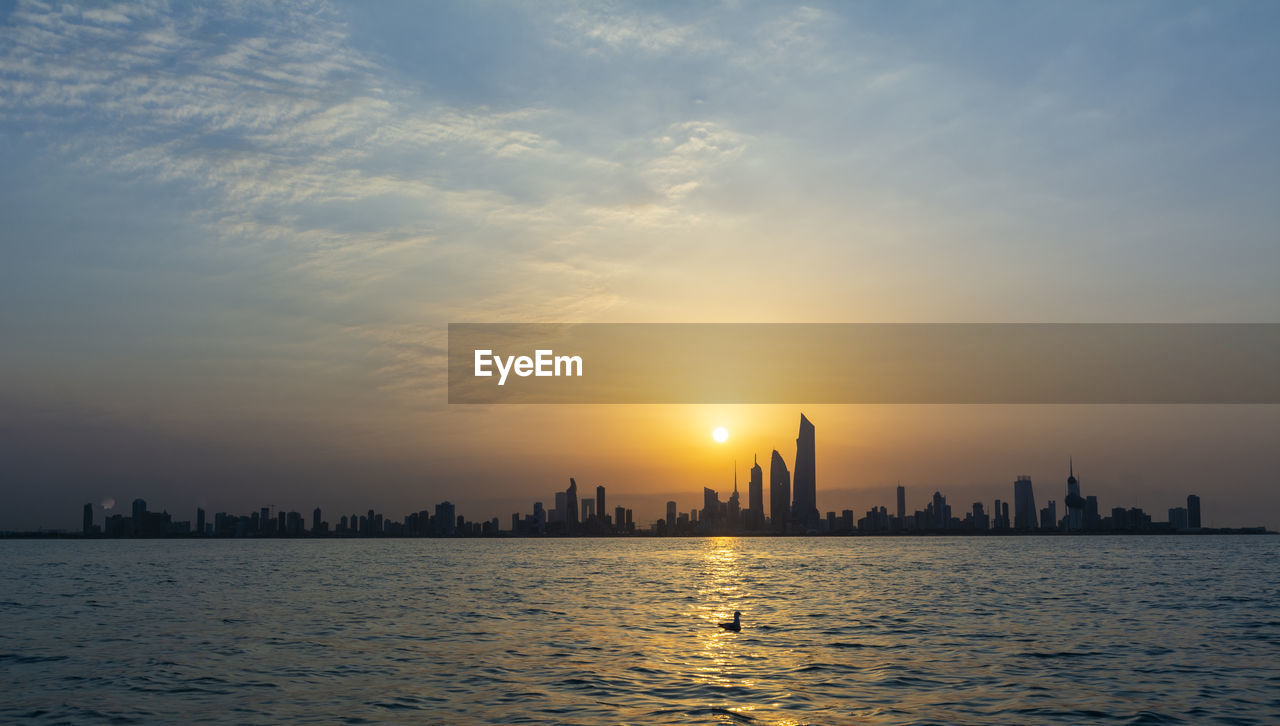 City at waterfront during sunset