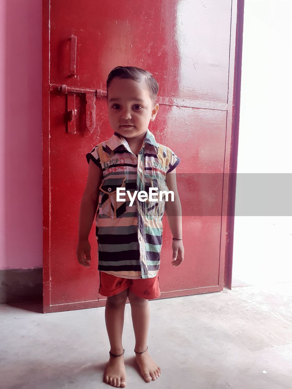 FULL LENGTH PORTRAIT OF BOY STANDING IN FRONT OF DOOR