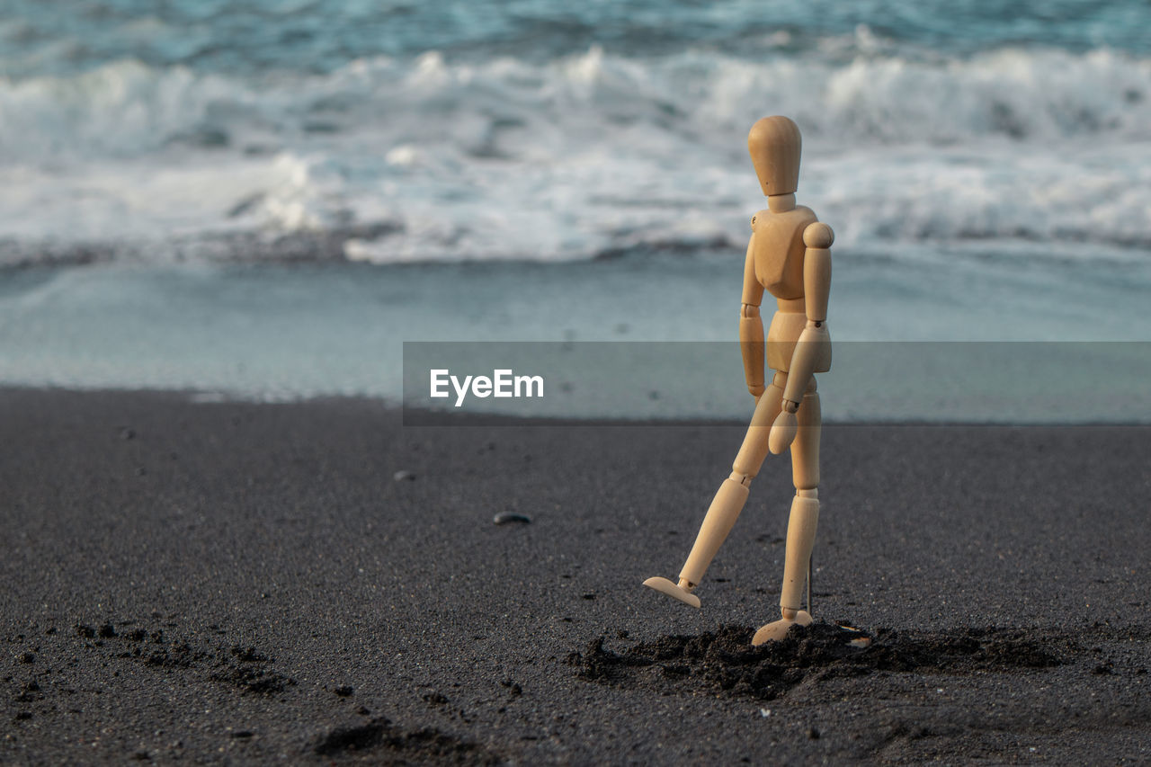 Figurine on sand at beach