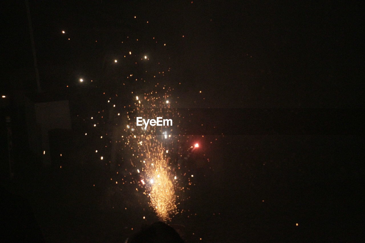 Low angle view of firework display in sky at night