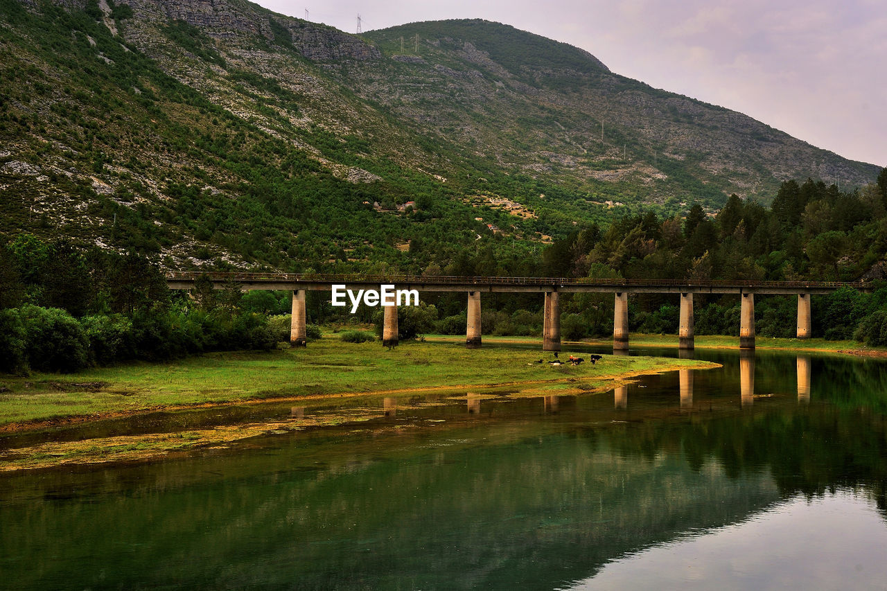 Bridge over river against mountain