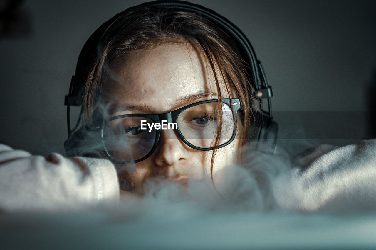 Portrait of girl wearing eyeglasses on bed