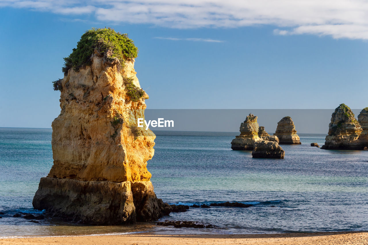 SCENIC VIEW OF ROCK FORMATION ON BEACH AGAINST SKY