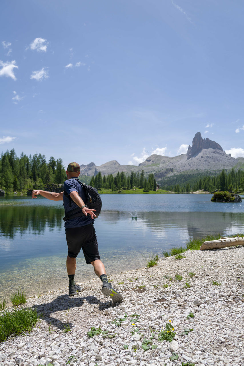 Man throwing stone in the water in the lake