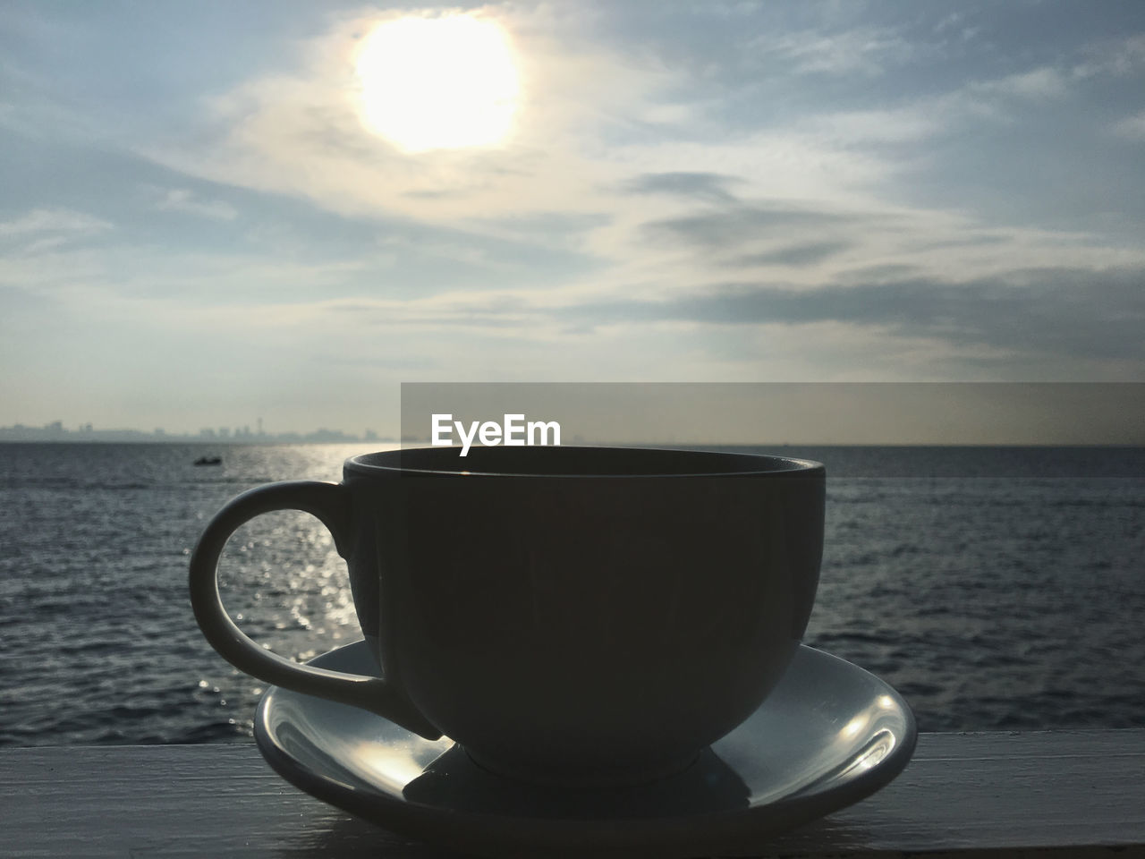 COFFEE CUP ON TABLE AGAINST SEA