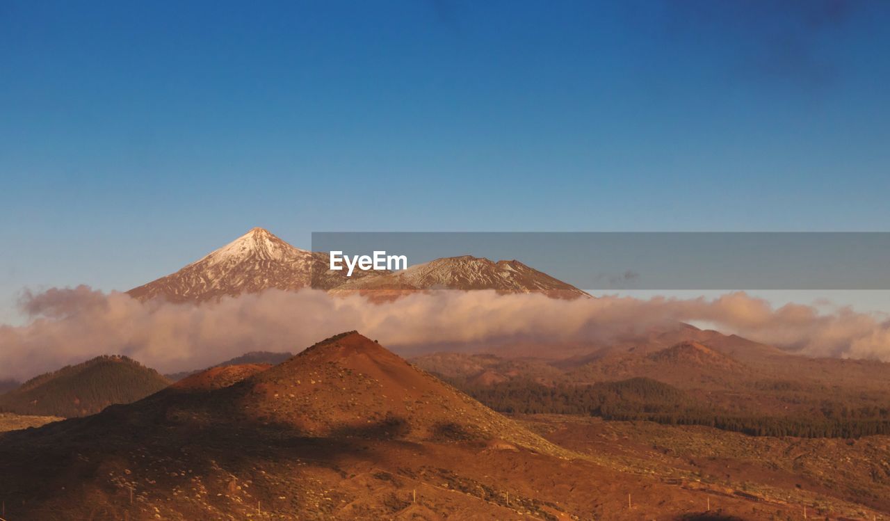 Scenic view of mountains against clear blue sky