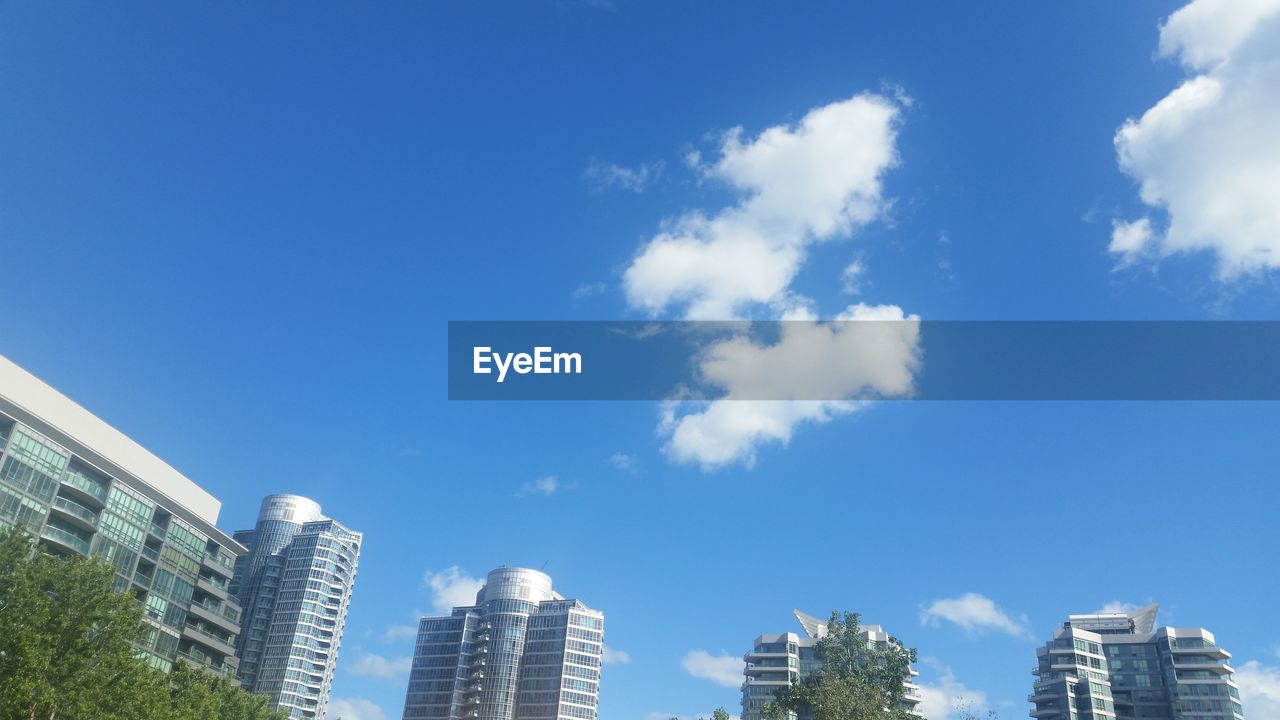 Low angle view of skyscrapers against blue sky