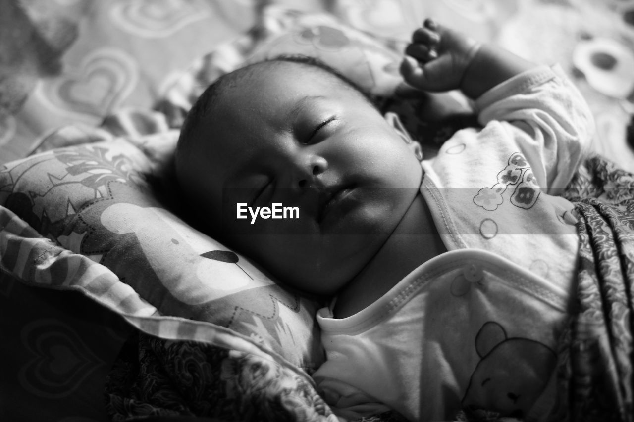 Close-up of baby girl sleeping on bed