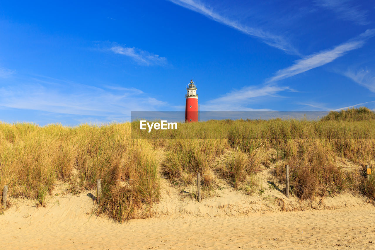 Lighthouse at the beach against sky