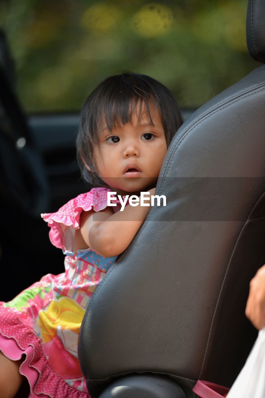 Portrait of cute girl sitting in car