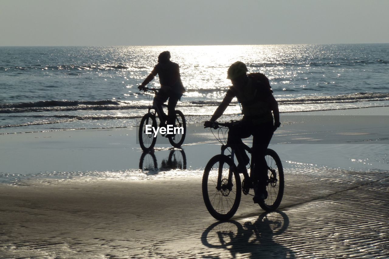 BICYCLES ON BEACH AGAINST SEA