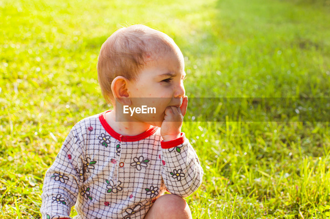 Cute girl slitting on grass at park