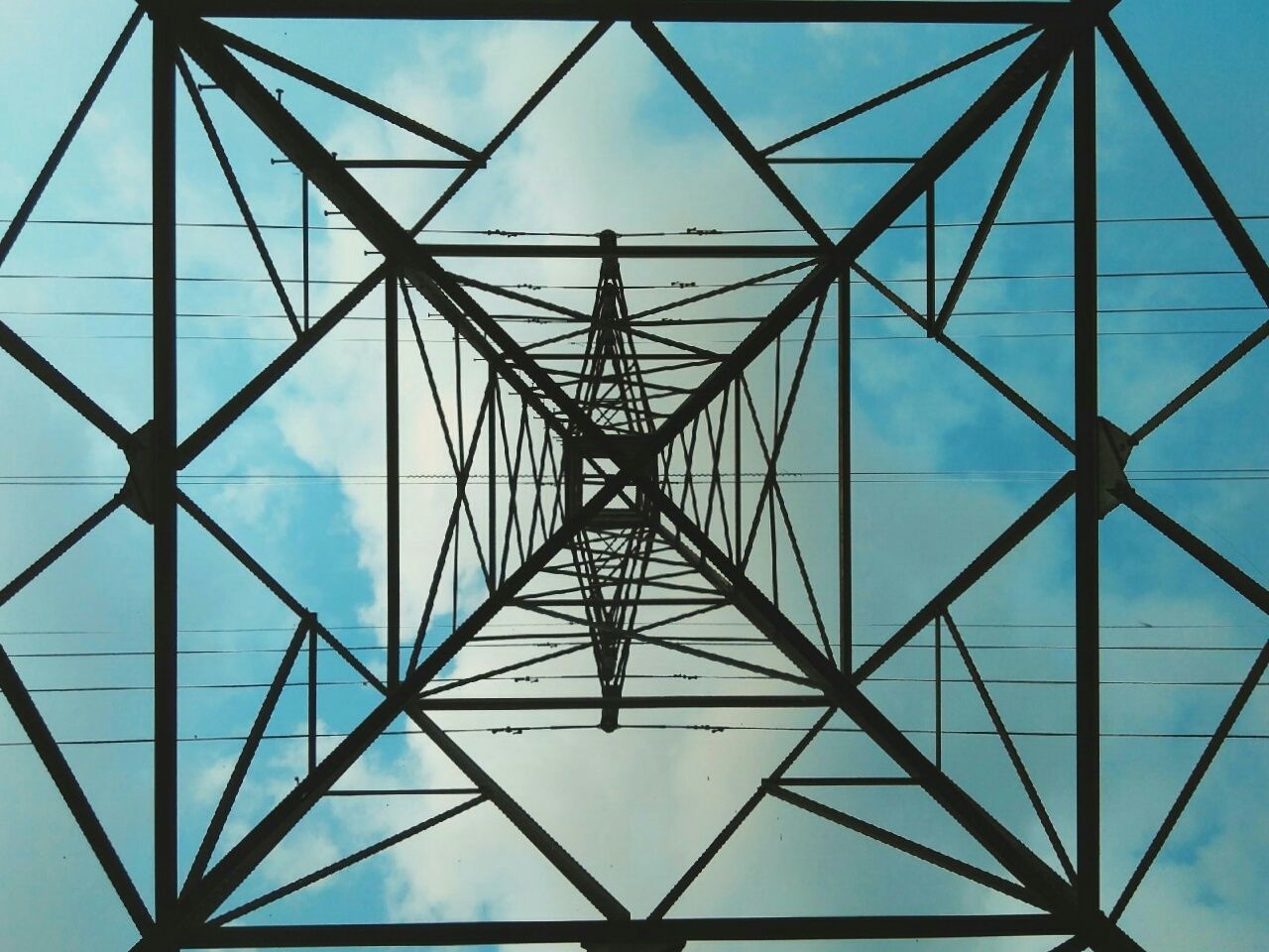 LOW ANGLE VIEW OF ELECTRICITY PYLONS AGAINST BLUE SKY