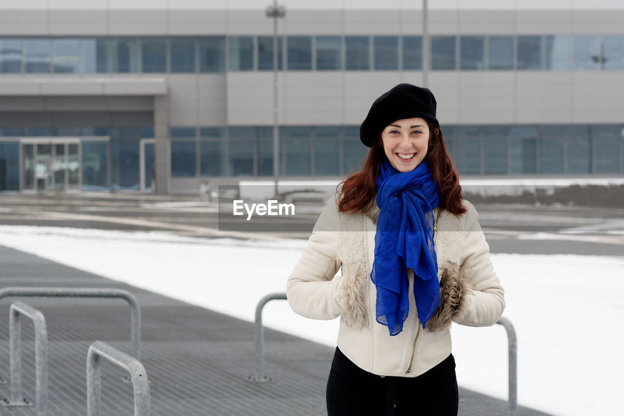 Portrait of smiling young woman standing in winter