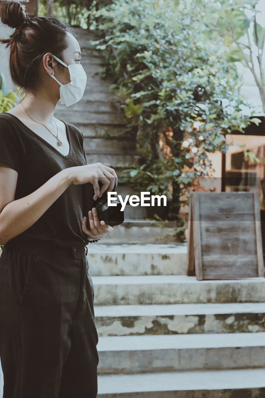 Cinematic style of young women hand holding camera and looking at faraway