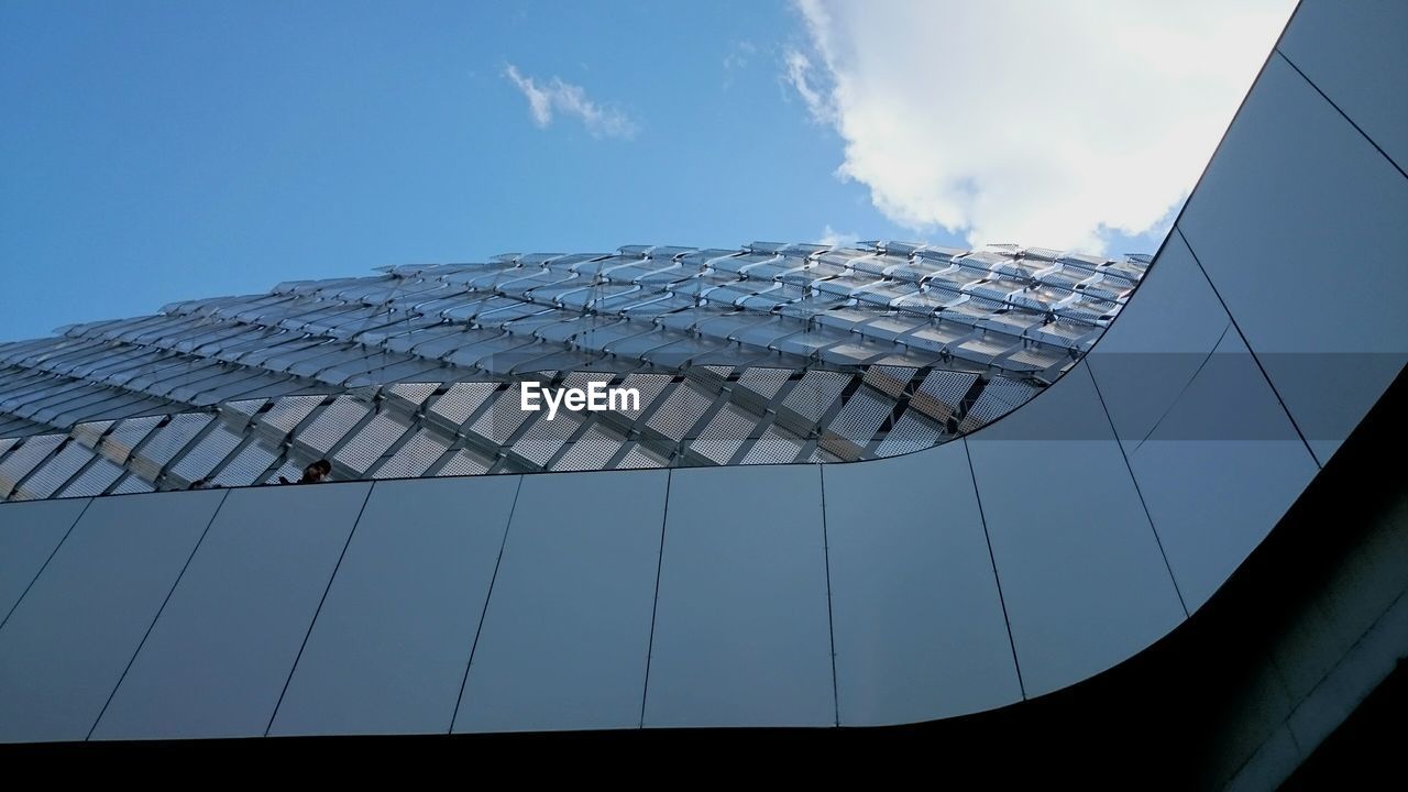 Low angle view of modern soccer stadium against sky