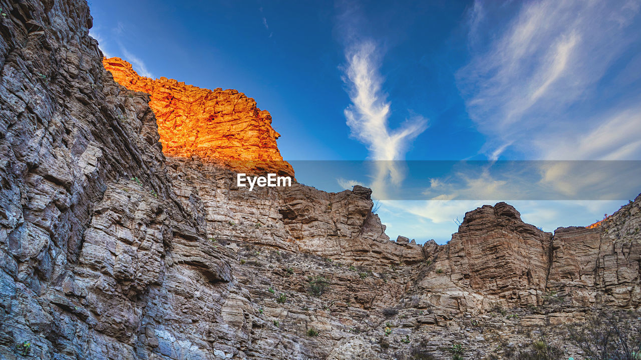 LOW ANGLE VIEW OF ROCK FORMATION ON MOUNTAIN AGAINST SKY