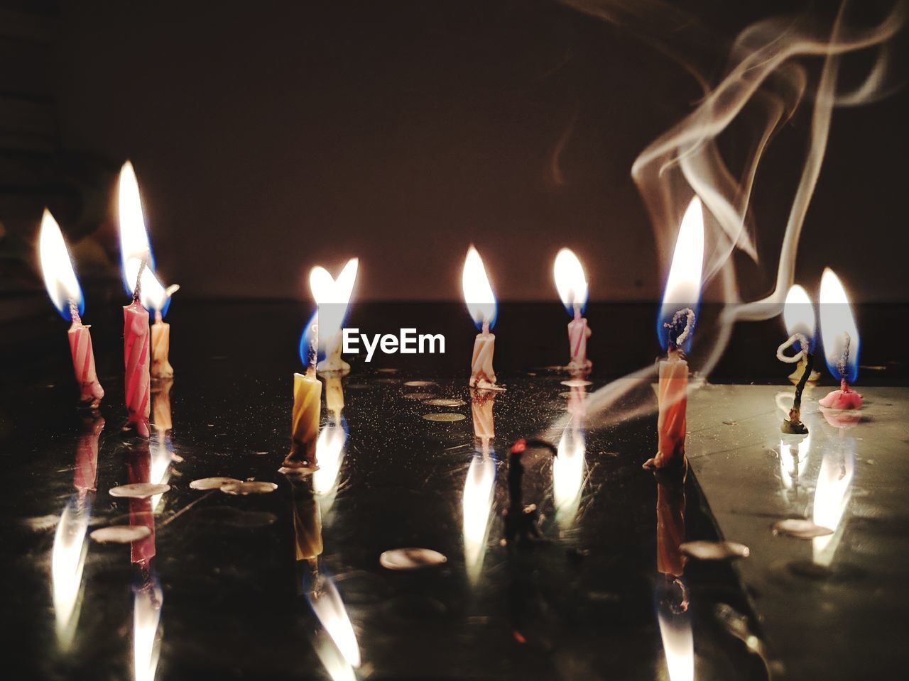 Close-up of burning candles on table