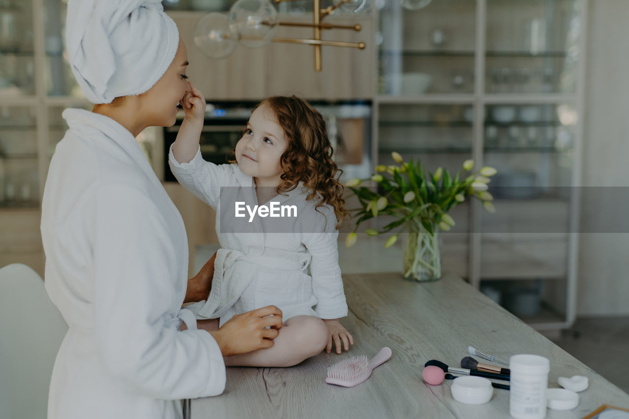 Smiling mother with daughter at home