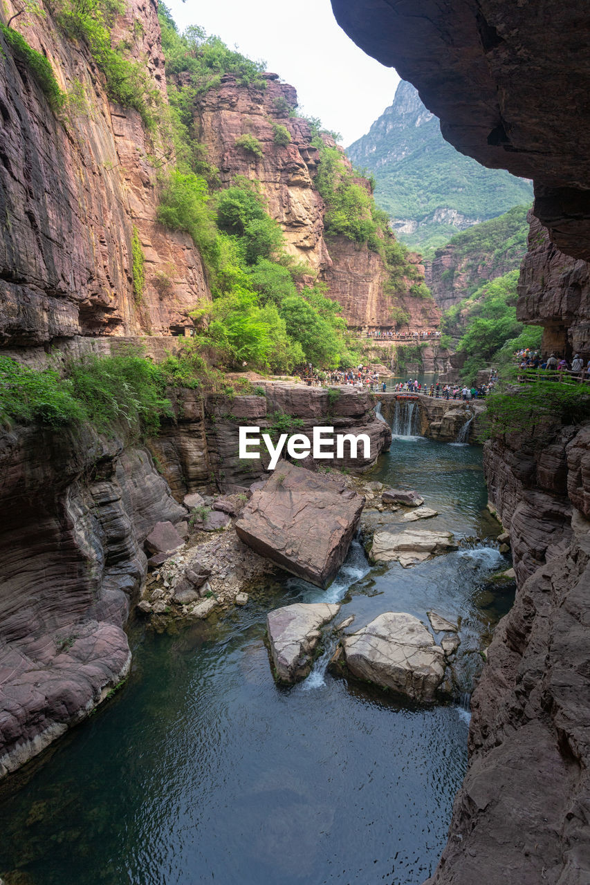 rock, water, rock formation, canyon, nature, beauty in nature, wadi, scenics - nature, land, travel destinations, environment, cliff, travel, non-urban scene, landscape, tranquility, no people, river, mountain, plant, valley, tree, geology, outdoors, sky, terrain, tourism, tranquil scene, day, natural arch, eroded, idyllic, physical geography, formation, architecture, ravine, holiday, trip