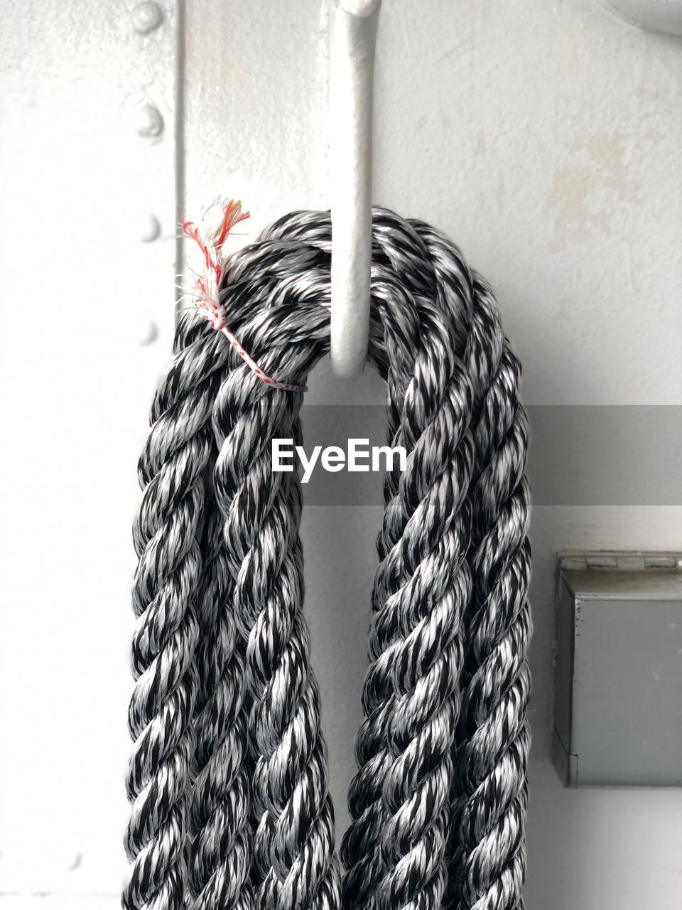 Close-up of rope tied on metal against wall