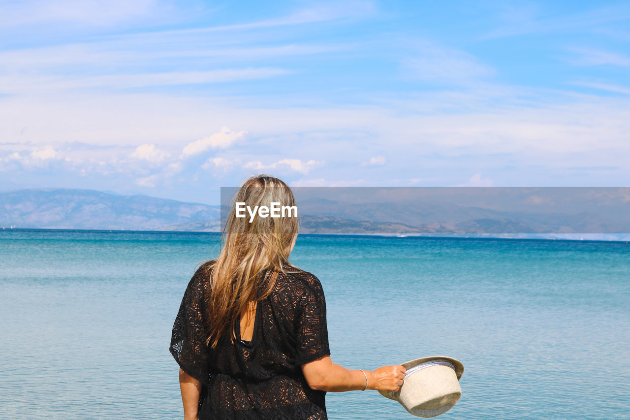 Rear view of woman looking at sea against sky