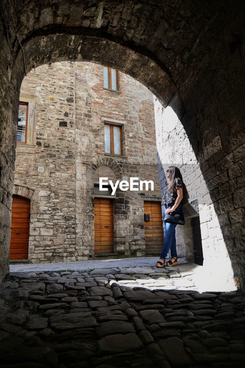 Woman standing below arch in city