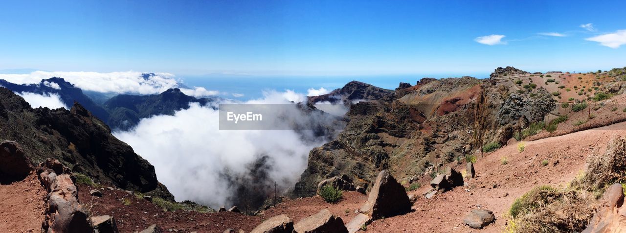 Panoramic view of mountains against blue sky