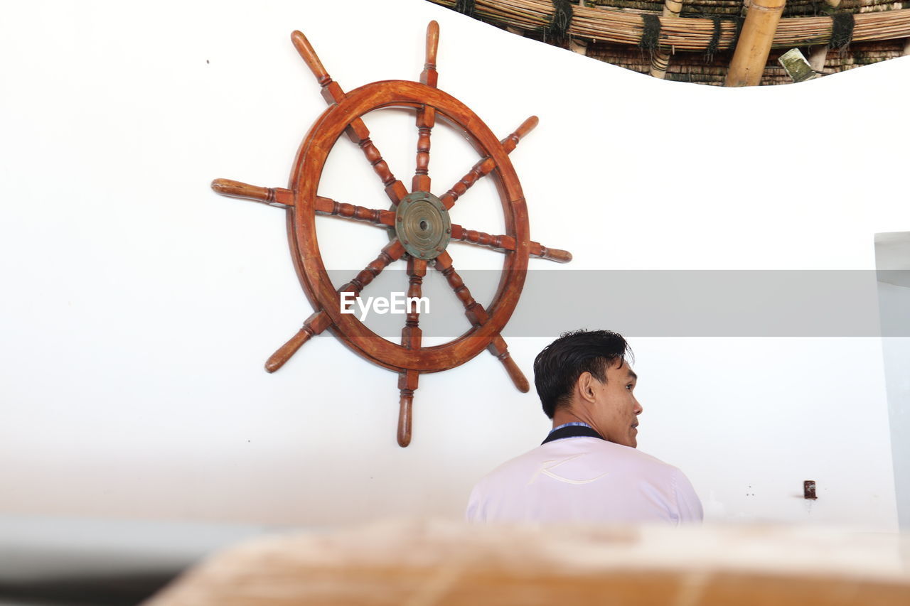 Rear view of man looking at camera