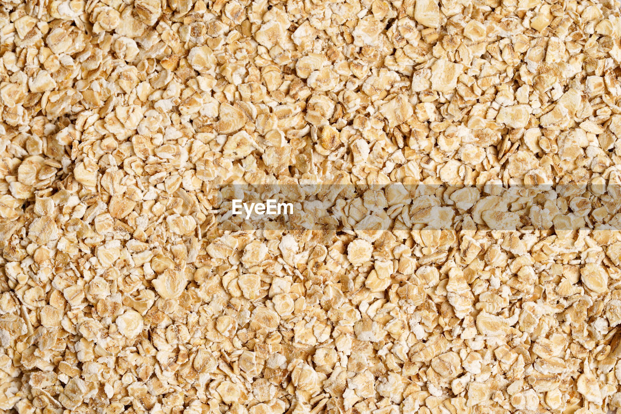 Rolled oat, oat flakes background or texture. close up, directly above.