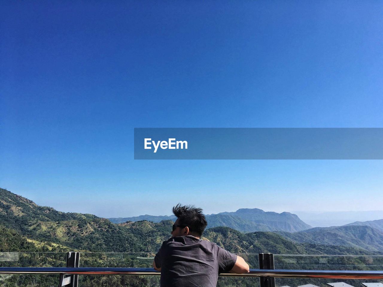 Man photographing against clear blue sky