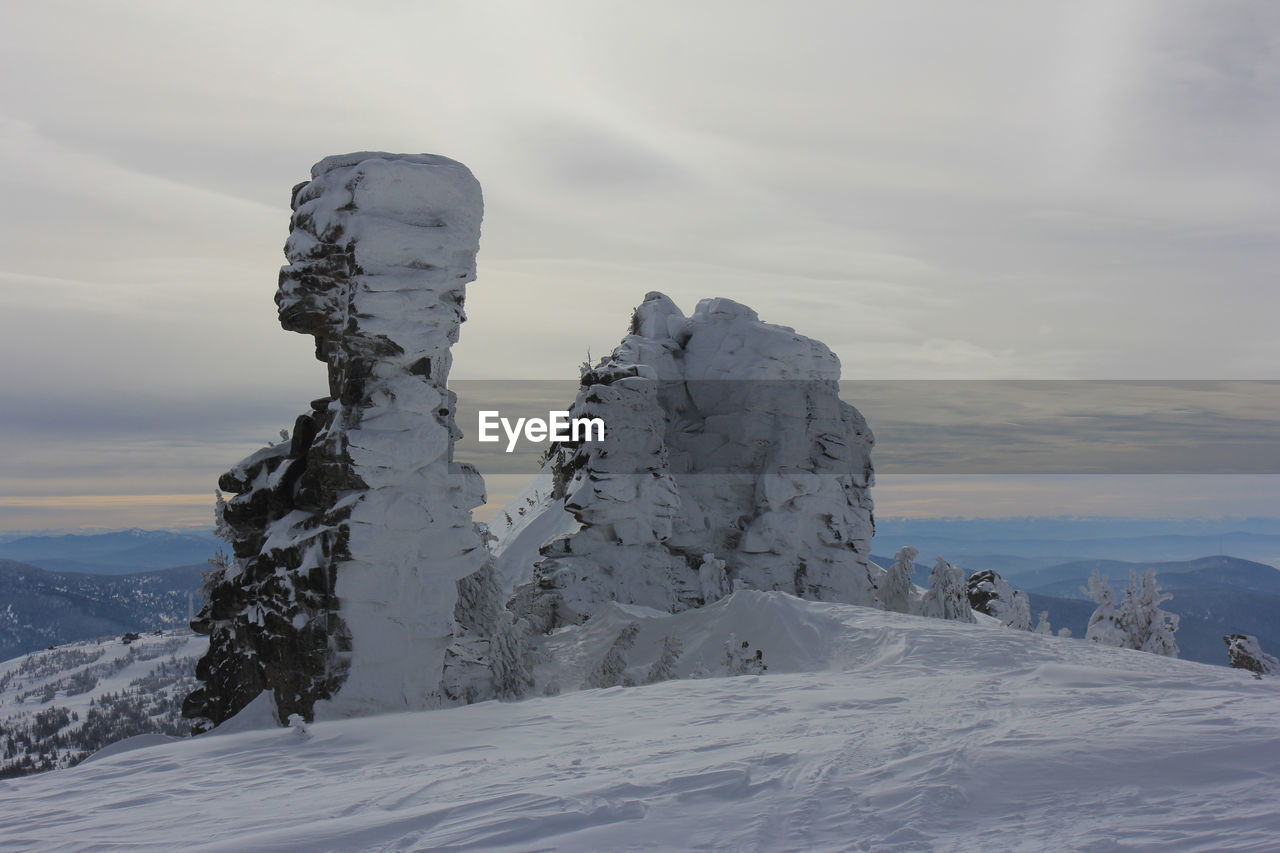 SNOW COVERED LANDSCAPE AGAINST SKY DURING WINTER