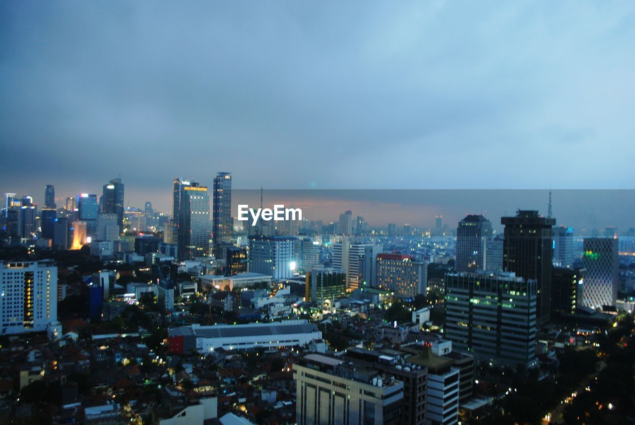 VIEW OF ILLUMINATED CITYSCAPE AGAINST SKY