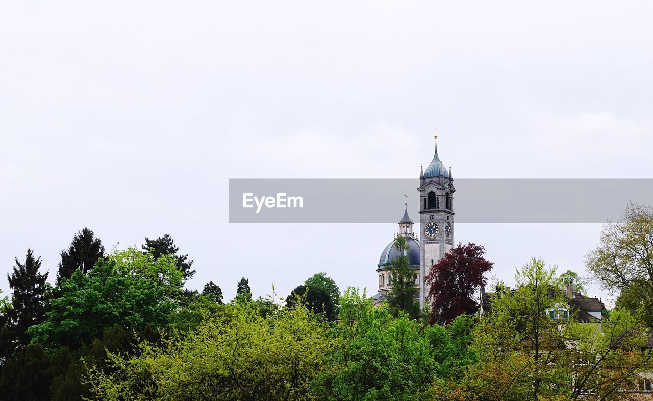 View of clock tower and dome behind trees