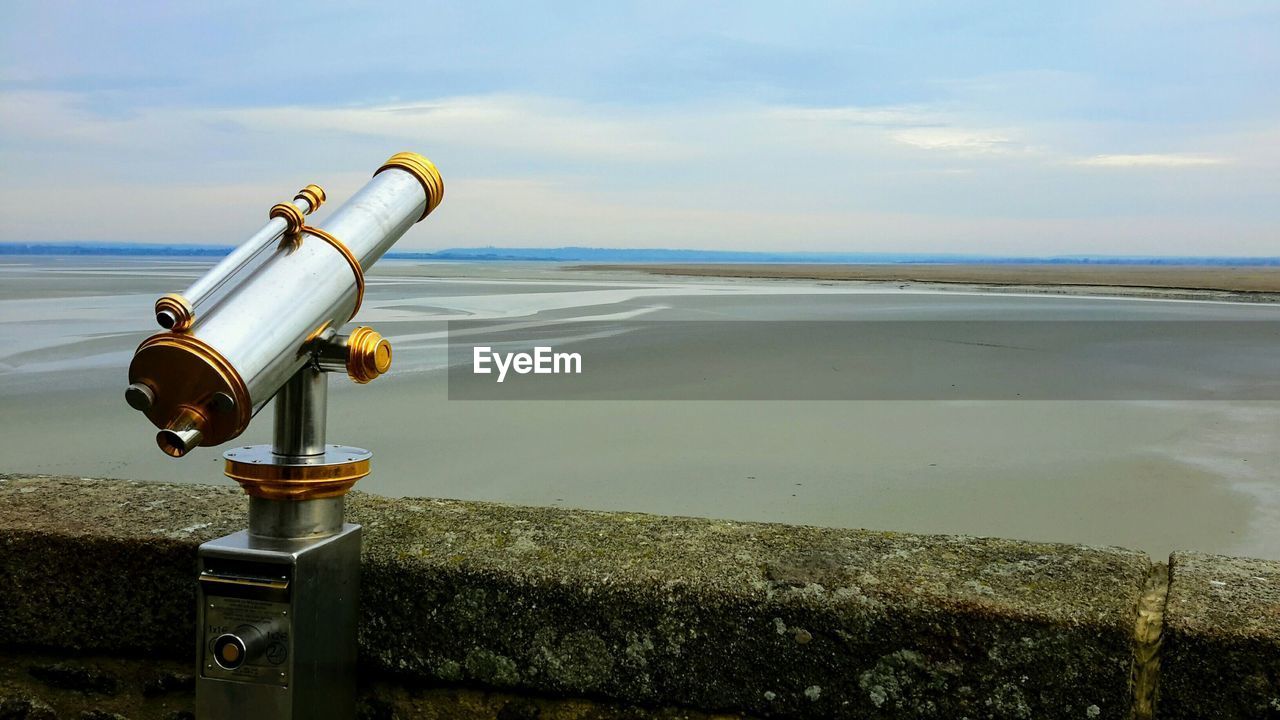 CLOSE-UP OF COIN-OPERATED BINOCULARS AGAINST SKY